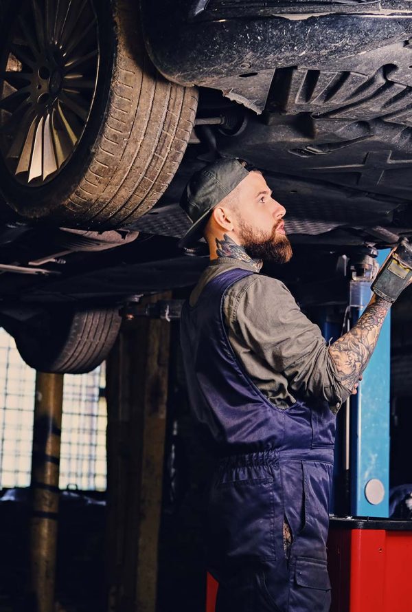 bearded-mechanic-working-with-the-cars-chassis-in-small.jpg