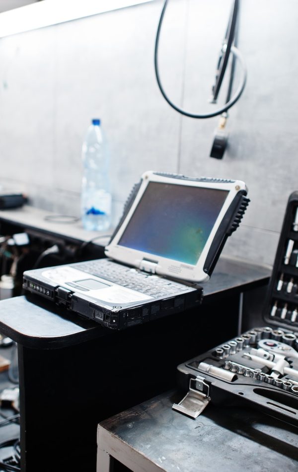 Laptop and tools in maintenance at garage service station.